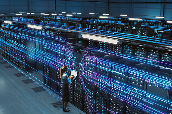 software tech standing inside a datacenter monitoring data